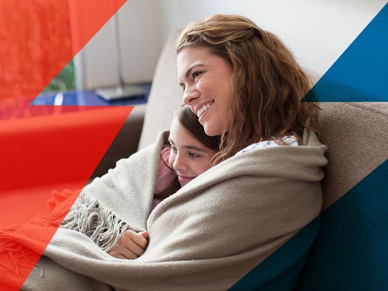 Mom and daughter cuddling under blanket